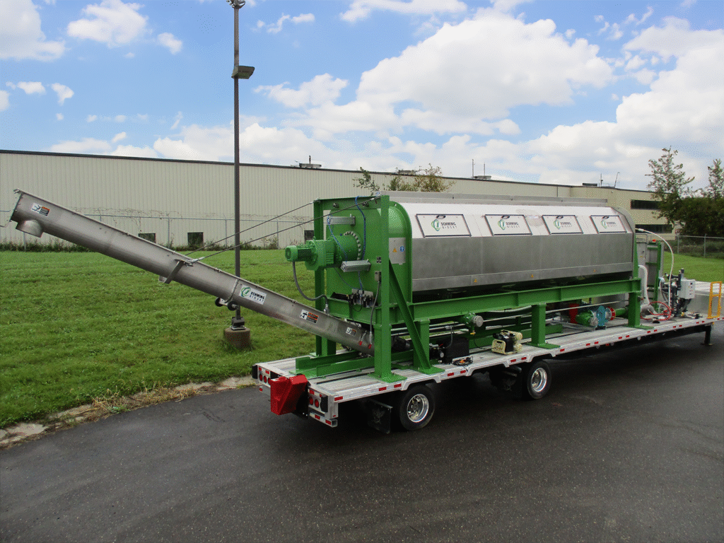 Schwing Bioset Mobile Screw Press dewatering unit on a trailer in a parking lot